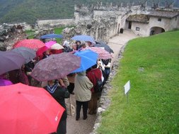 Mit Regenschirm unterwegs entlang der Schlossmauern